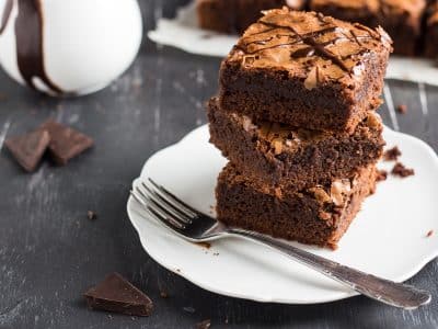 Chocolate brownie cake piece stack on plate homemade pastries sweet cooking with melted chocolate on dark background
