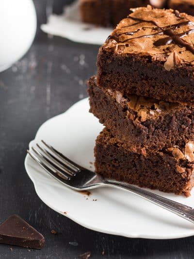 Chocolate brownie cake piece stack on plate homemade pastries sweet cooking with melted chocolate on dark background